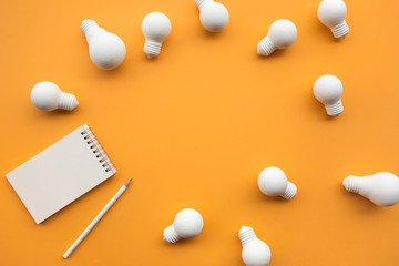 Creativity concepts with group of lightbulb and notepad on pastel color background