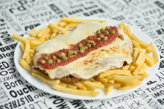 Plato de milanesa con papas fritas y queso