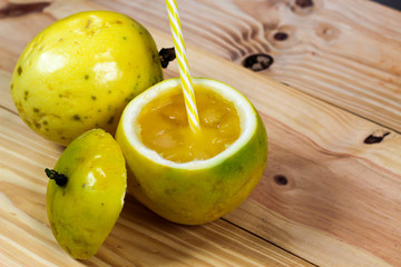 Passion fruits half and juice on the vintage wooden background. Closeup, Select focus.