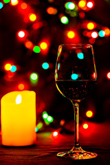 Wine glass filled with red wine, and candle