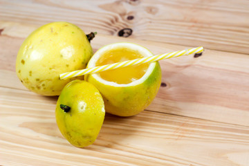 Passion fruits half and juice on the vintage wooden background. Closeup, Select focus.