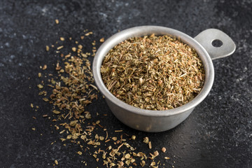 Dried Oregano Spilled from a Measuring Cup