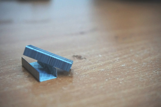 Staple that will be driven by stapler through sheets of paper to fasten them together