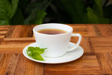 Mulberry leaf tea in cup placed on a wooden floor
