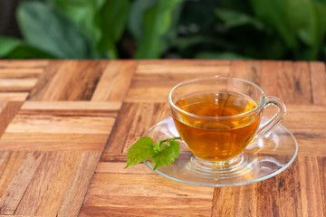 Mulberry tea leaves in a glass Placed on a wooden floor