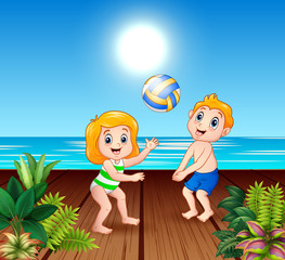 Obraz na płótnie Canvas Children playing volleyball on the sea pier