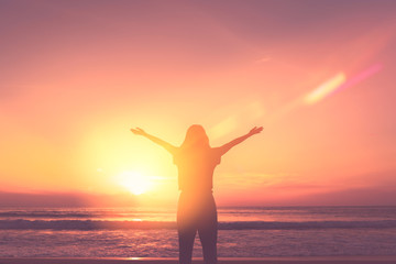 Fototapeta na wymiar Copy space of woman rise hand up on sunset sky at beach and island background.