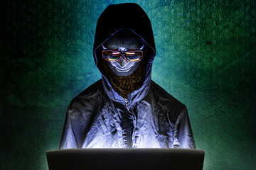 Mannequin and laptop in dark tone for cyber crime content.
