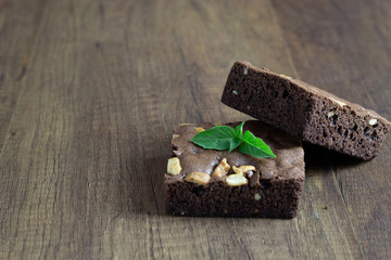 The 2 pieces of brownies on the top of the wood with basil leaves with path