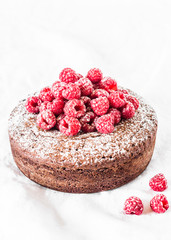 Chocolate nut cake with raspberry on light background. Delicious dessert