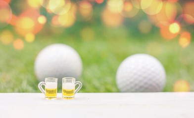 Golf ball with glasses of beer with golf ball background 