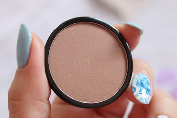 Bronze corector blush in woman's hand