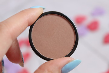 Bronze corector blush in woman's hand