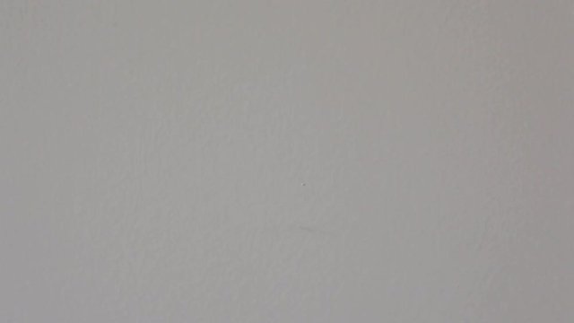 Person takes off yellow sticker saying no and then puts it back on white wall