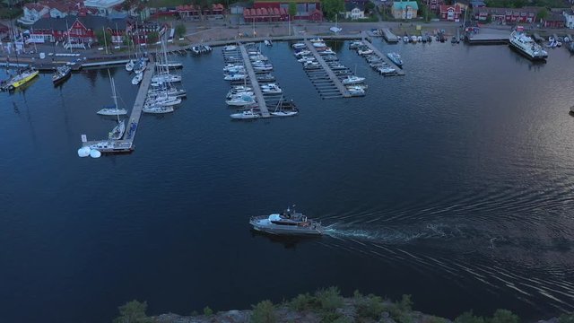 A luxury yacht arrives at Sandhamn marina, a town on the Stockholm Archipelago. Aerial drone shot