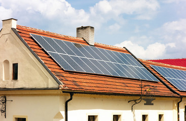 Contrast of the old house and modern technology as it is using solar roof