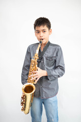 Fototapeta premium Little asian musician boy playing saxophone instrument