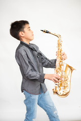 Fototapeta na wymiar Little asian musician boy playing saxophone instrument