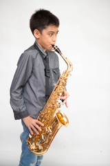 Fototapeta premium Little asian musician boy playing saxophone instrument