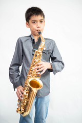 Fototapeta premium Little asian musician boy playing saxophone instrument