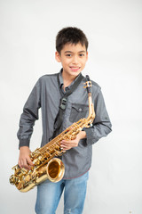 Fototapeta premium Little asian musician boy playing saxophone instrument