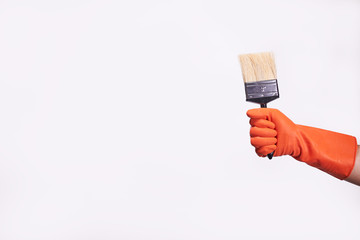 close up hand wearing glove holding paintbrush for colors painting. Painter holding brush for painting house on the isolated background.