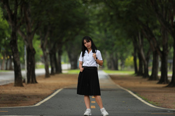 Portrait Of Female Teenage University student uniform between the tree