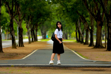 Portrait Of Female Teenage University student uniform between the tree