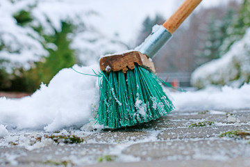 Man removing snow from the sidewalk after snowstorm.