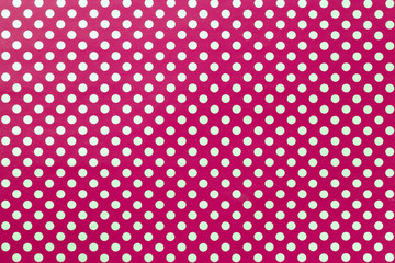 Dark red background from wrapping paper with a pattern of golden polka dot closeup.