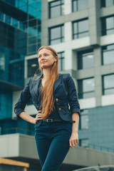 portrait of a beautiful girl with red haired on the background of the urban landscape