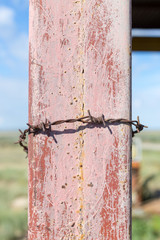 barbed wire on an iron rack against the blue sky