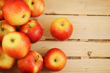 Naklejka na ściany i meble Red apples on wooden crate bottom