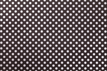 Black background from wrapping paper with a pattern of white polka dot closeup.
