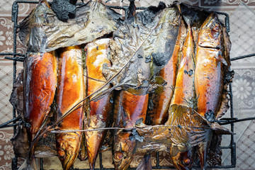 Freshly cooked hot smoked mackerel fish on the grill.