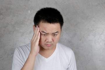 Portrait Young Asian men unhappy Use the handle on the head showing headaches, stress, migraines isolated on gray background Health concept