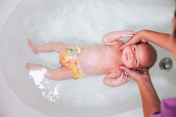 Newborn baby swimming in bath