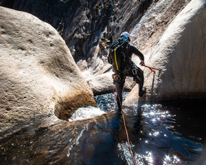 Canyoneer Sets Anchor Above Granite Waterfall