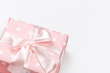 Gift box wrapped in pastel  paper with pink ribbon isolated