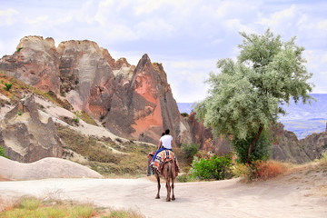 Tourists ride a camel, Pasabag Valley, Cappadocia, Turkey
