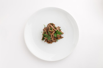 Fried sauteed beef strips with parsley isolated on white background