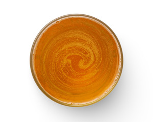 top view of beer bubbles in glass cup on white background.