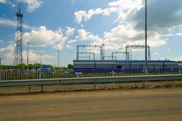 Fototapeta na wymiar Electric substation on a sunny summer day, clouds in the sky