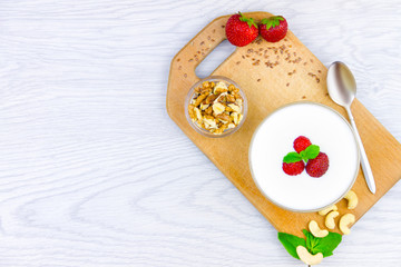 Healthy fitness low calories breakfast: yogurt with cashew and walnuts for healthy lifestyle and fitness diet isolated on white background. Ready for breakfast. Healthy food concept