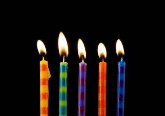 Burning birthday candles on black background