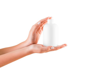 Female hand holding cream bottle of lotion isolated. Girl give tube cosmetic products on white background