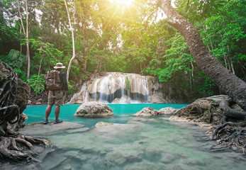 Traveler is watching beautiful scene nature background from Earawan Waterfalls in Kanchanburi, Thailand during rainy season.