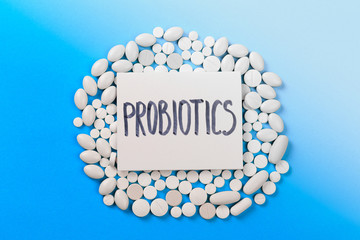 probiotics white  dragee on blue background  - Image