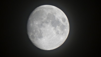 Fototapeta premium Closeup of moon image 2 days before full moon at night without clouds in summer season, full moon is the lunar phase when the Moon appears fully illuminated from Earth's perspective.