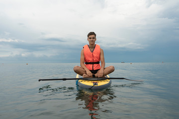 Surfer in life jacket on a sup surfboard, Concept safety on the water